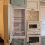 Холодильник, встроенный в шкаф и выполненный в том же цвете и материале, как и весь кухонный гарнитур